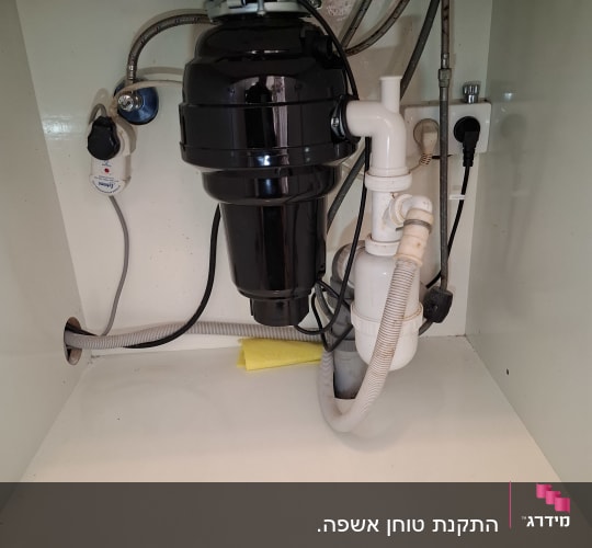 מתקן אינסטלציה מתחת לכיור עם צינורות וחיבורים